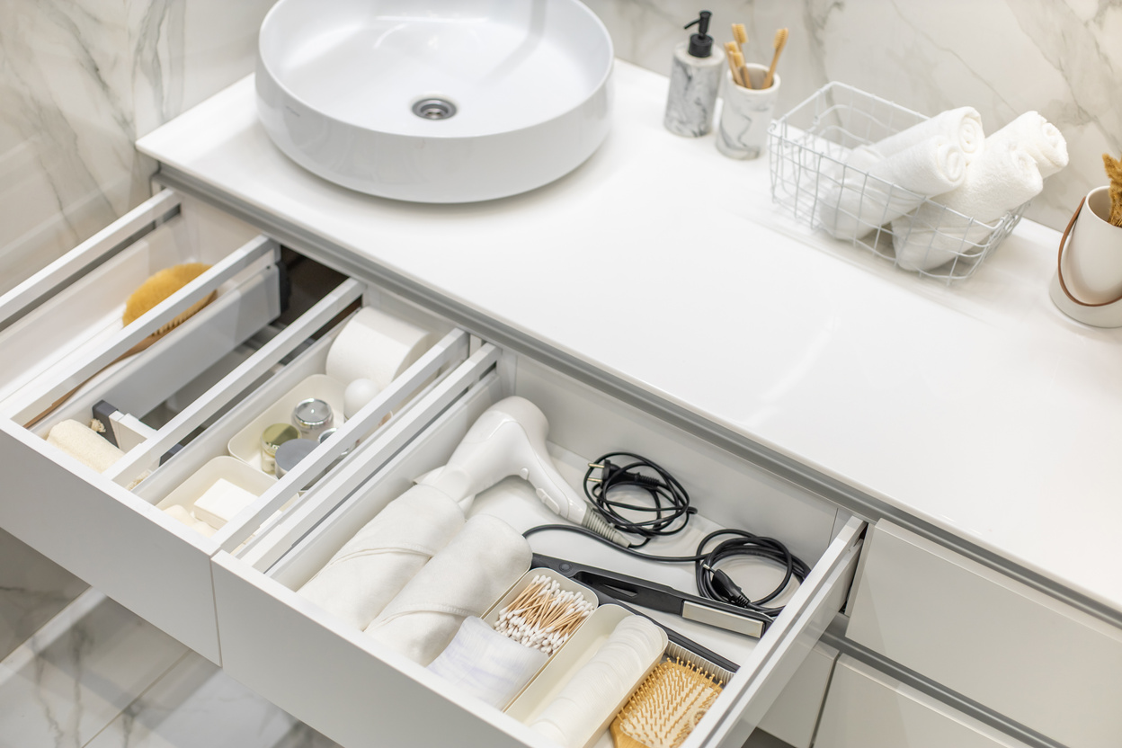 Bathroom under sink organizer drawers with neatly placed bath amenities and toiletries